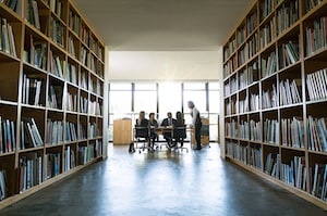 Group of people in library with shelves of books