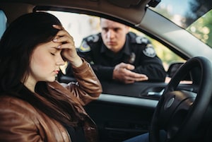 Woman at wheel of car upset with cop in window